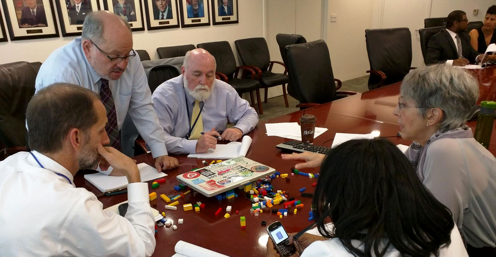 A group of government executives playing with legos.