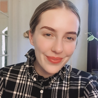 Carly Jugler (she/her) smiling at the camera
