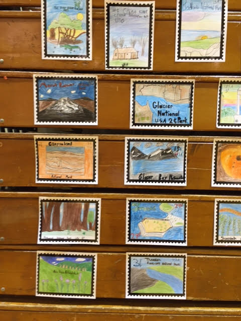 Stamps for Glacier, Glacier Bay, Canyonlands, and other national parks drawn and colored by the fourth graders.